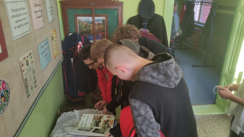 Na zdjęciu uczniowie ZSOiZ w Gryfowie Ślaskim, znajdująs się w klasie muzealnej w Szkole Podstawowej nr 2, pochylają się nad książką ze zdjęciami
