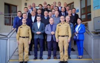 grupa uczestników szkolenia stojąca na schodach ok 20 osób